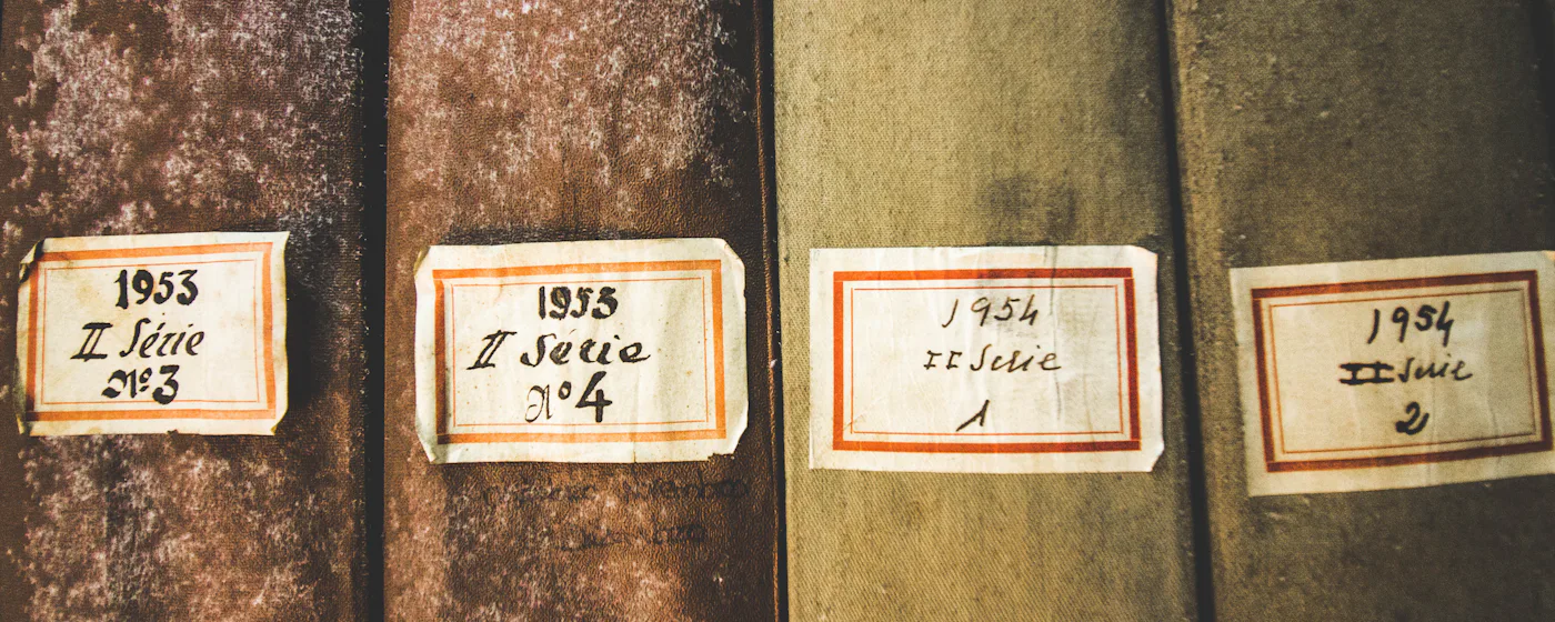 Bound archive volumes with hand-lettered paper spine labels